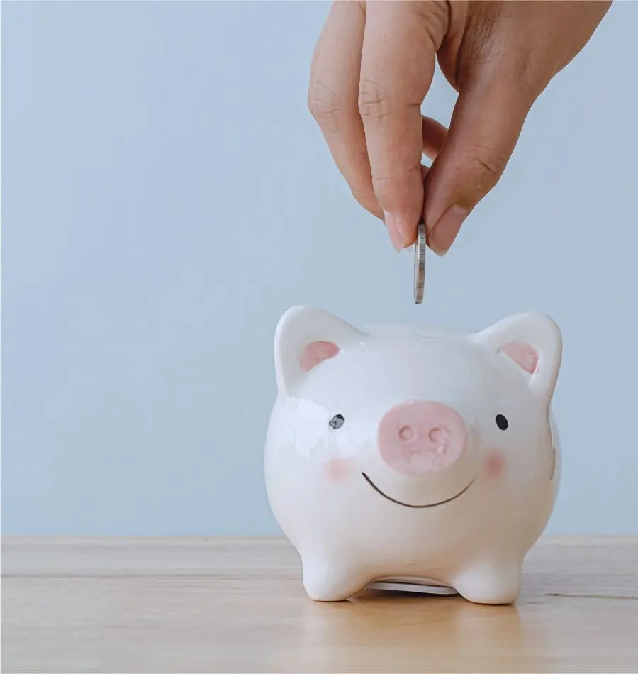 A person puts a coin into a piggy bank.