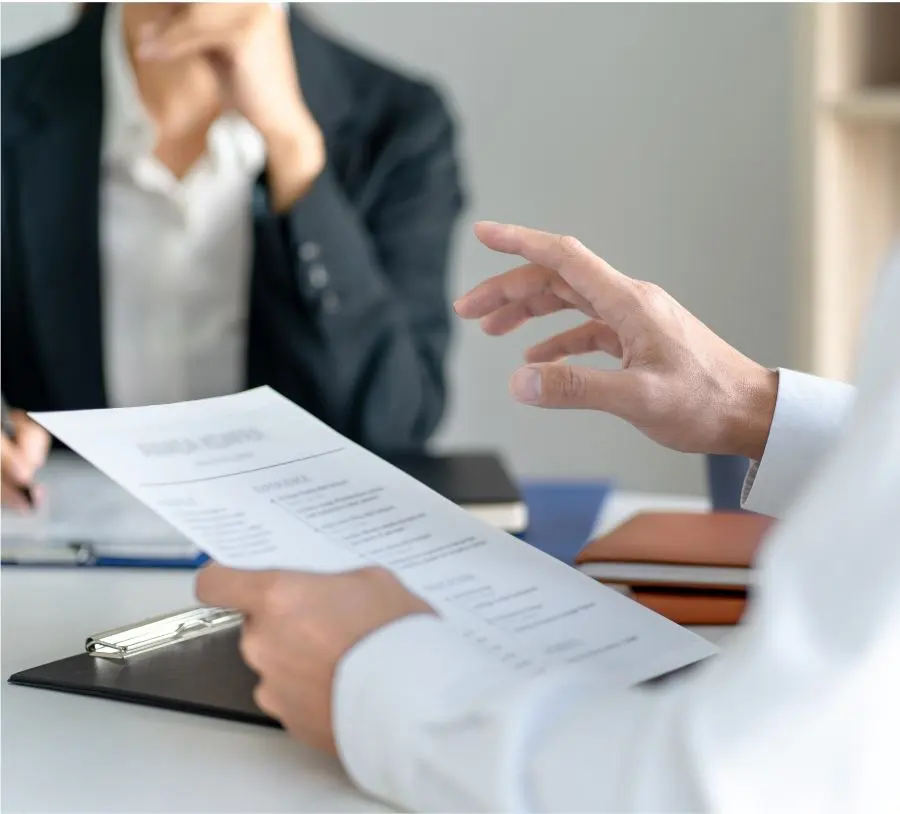 A man holds a sheet of paper in his hands during a meeting.