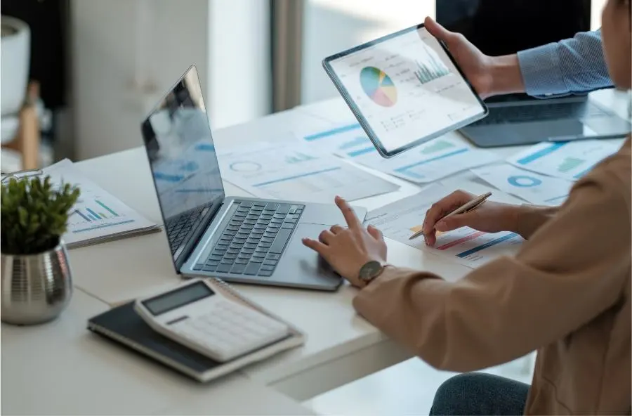 A picture of a laptop and various graphics lying on a table during a meeting.