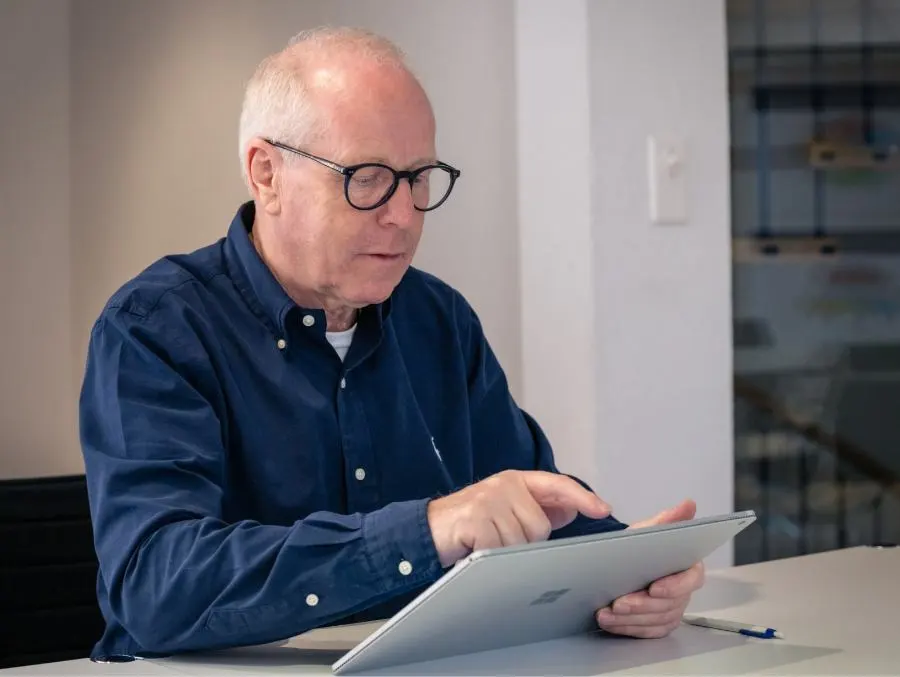 A man from the future-cube team works intently on a tablet.