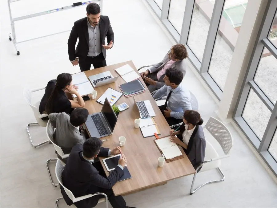 Picture of a meeting with seven people from a bird's eye view.