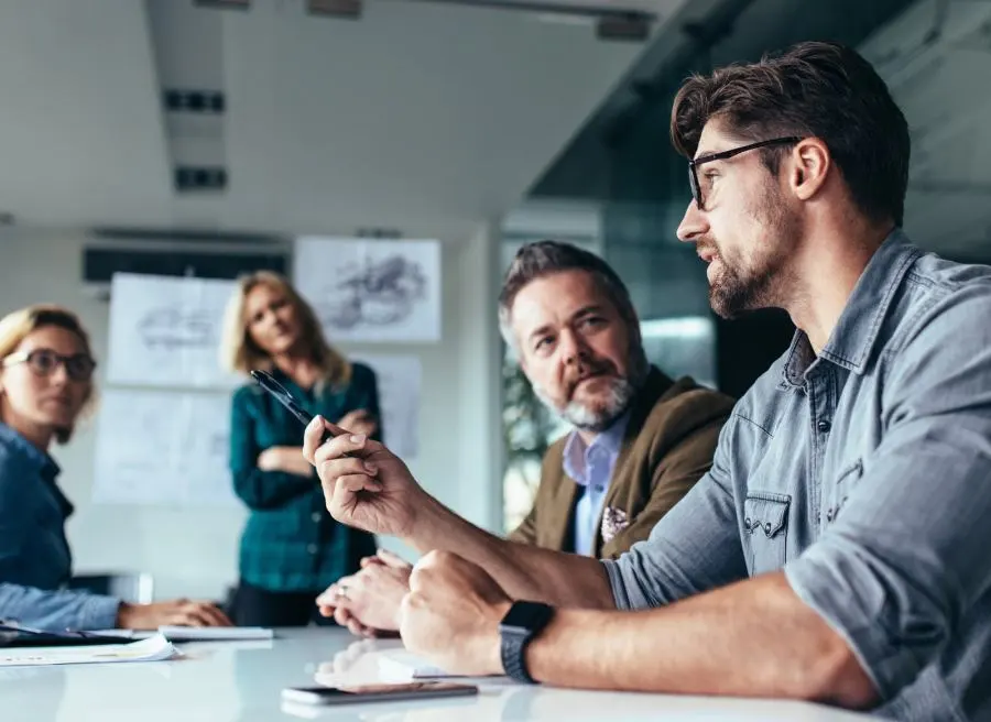 A man is sharing his thoughts with the team during a meeting.