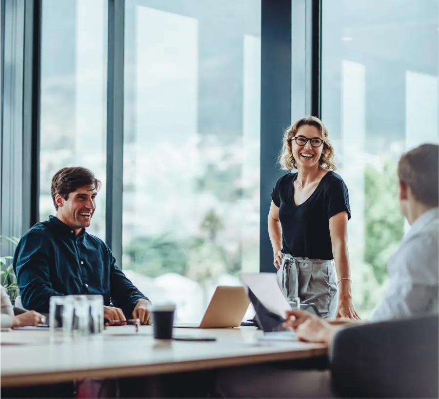 A laughing woman and a laughing man are in a meeting.