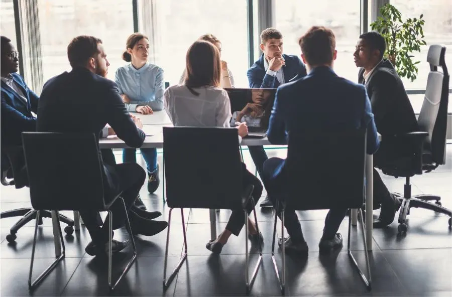 A group of young people are sitting in a meeting.