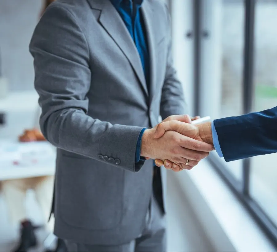 Two men shake hands.