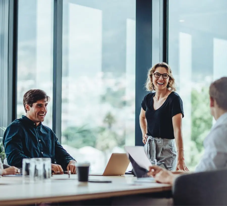 A laughing woman and a laughing man are in a meeting.