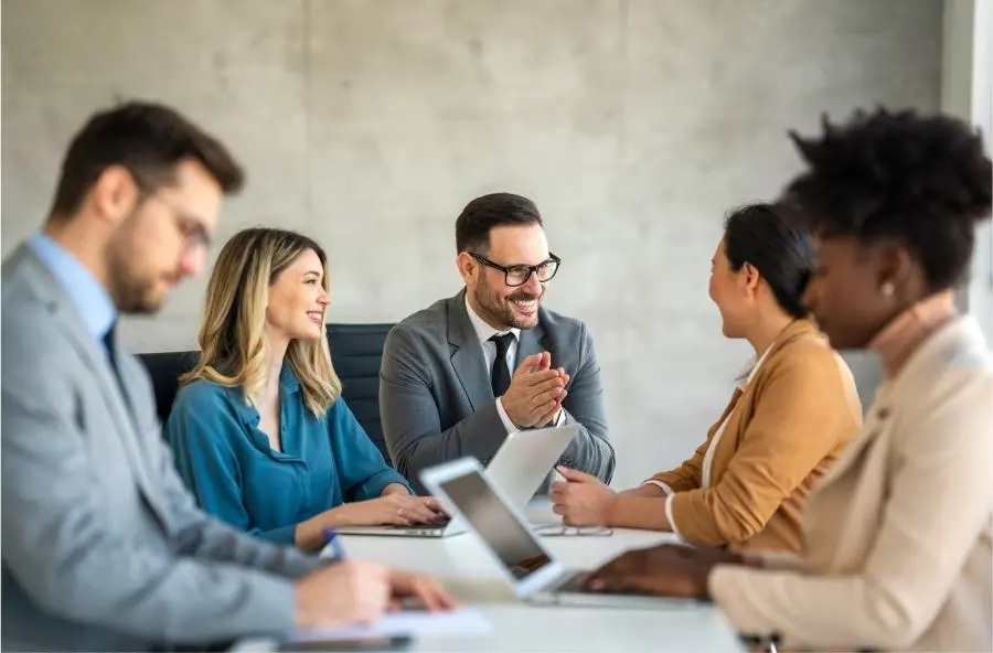 A man expresses his pleasure and appreciation to his team during a meeting.