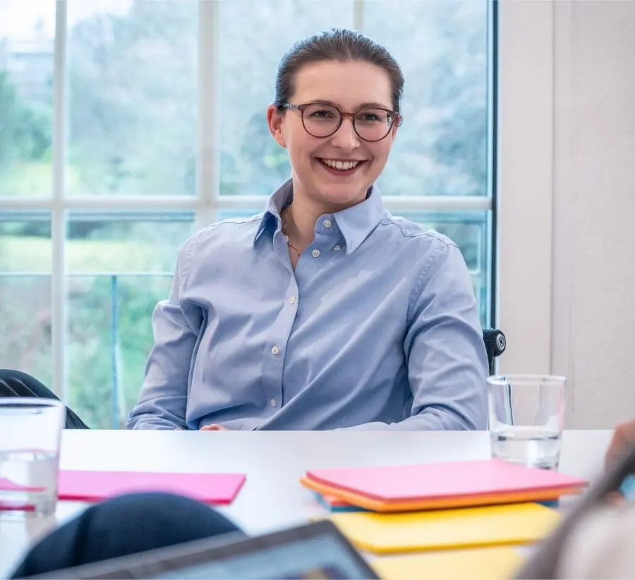 Picture of a smiling woman with glasses during a workshop.