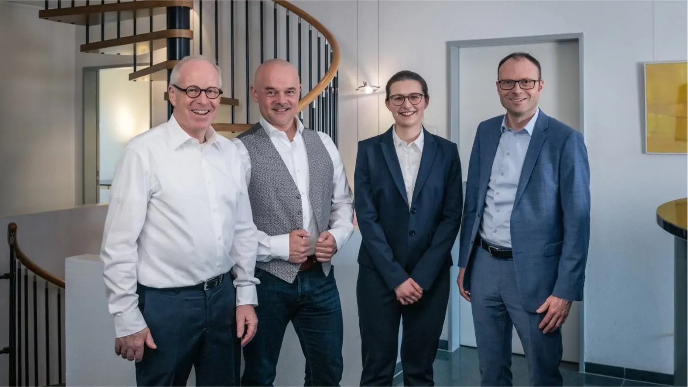 Group photo of the future-cube team in front of the spiral staircase in their office.